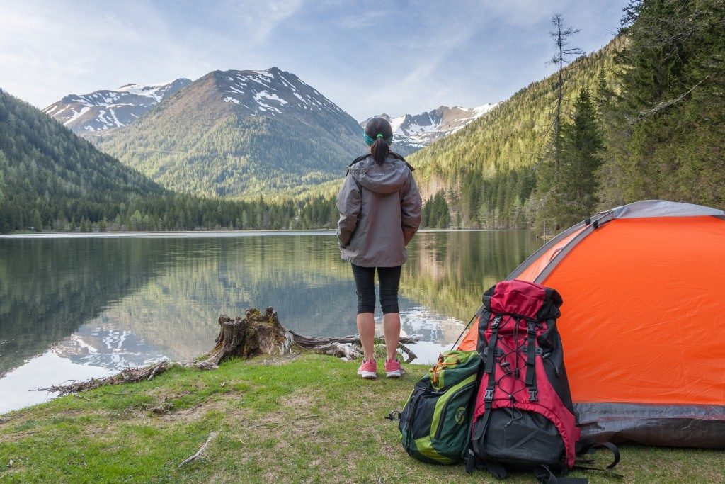 Woman camping in front of a lake