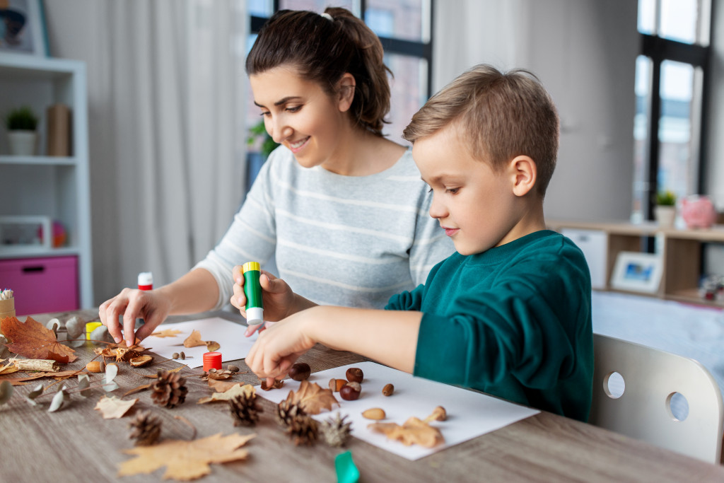 Mother and son doing a craft at home using pine cones