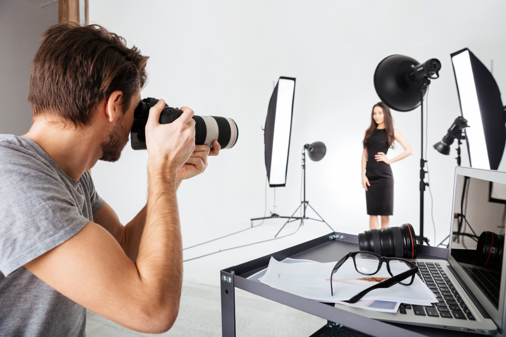 A professional photographer working with a model in a studio